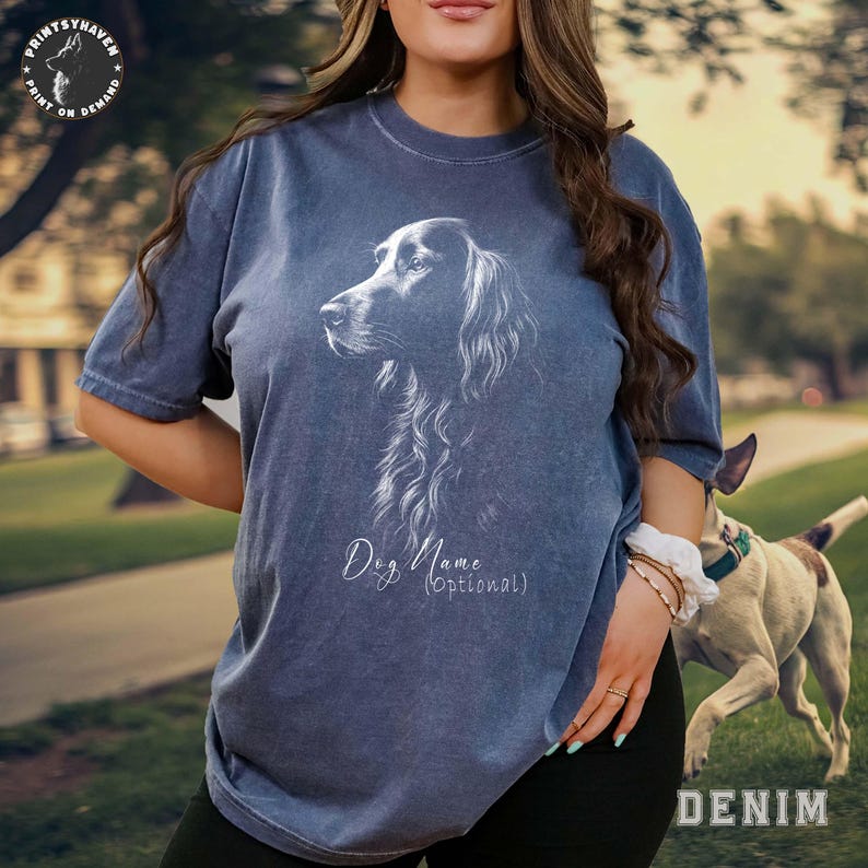 May include: Denim blue t-shirt featuring a detailed white illustration of a dog's profile. The shirt includes the text "Dog Name (Optional)" in a script font. The shirt is part of the Printsy Haven collection.