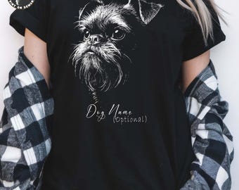May include: Black t-shirt featuring a detailed white illustration of a dog's face. The design includes the text "Dog Name (Optional)" in a cursive font. The shirt is a classic crew neck.