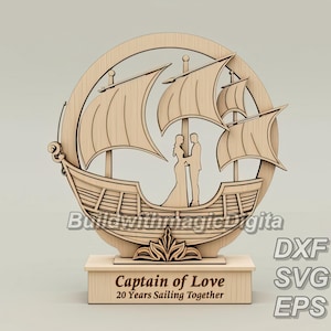 Könnte beinhalten: Holzschnitt eines Schiffes mit einem Paar, das auf dem Deck steht. Das Schiff hat zwei Segel und einen geschnitzten Holzsockel. Der Sockel trägt den Text "Captain of Love" und "20 Years Sailing Together".