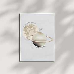 Puede incluir: Un fondo azul claro con una luna dorada y un planeta dorado con anillos. El texto "love you to the moon and to saturn" está escrito en negro.