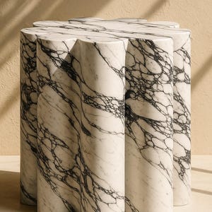 Könnte beinhalten: Ein Beistelltisch aus weißem Marmor mit einem einzigartigen, geriffelten Design. Der Tisch weist ein auffälliges Muster aus schwarzen Adern auf. Die zylindrischen Beine und die gewellte Oberseite schaffen eine moderne, skulpturale Ästhetik, ideal für ein Wohn- oder Schlafzimmer.