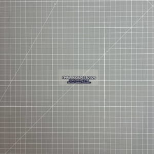 Peut inclure: Un autocollant rectangulaire portant le texte FINAL BUDAPEST 2026, PUSKAS ARENA 30 MAY, PARIS SAINT-GERMAIN VS ARSENAL FC en lettres noires sur fond blanc, centré sur un tapis de découpe gris avec une grille et des lignes diagonales blanches.