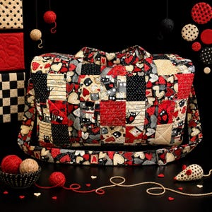 May include: A quilted duffel bag featuring a patchwork pattern of black, red, and cream fabric squares. The design includes illustrations of cats, hearts, and polka dots, with text reading "Life is better with my cat" and "Love my cat".
