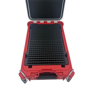 May include: Red, open, hard-shell case with a black interior. The case has a handle and two metal latches. The interior features a black foam insert with a grid pattern. The lid is open, revealing the interior.