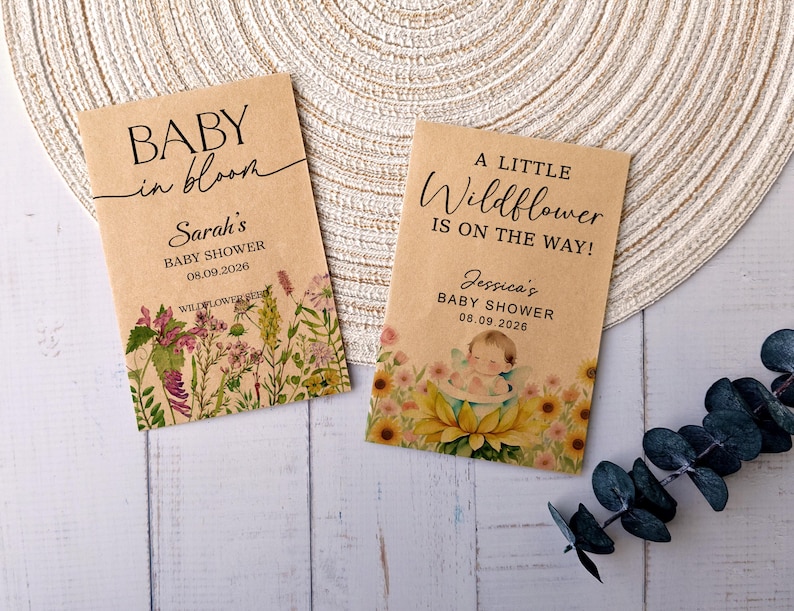 May include: Two kraft paper seed packets for a baby shower. One reads "BABY in bloom" and "Sarah's BABY SHOWER 08.09.2026". The other says "A LITTLE Wildflower IS ON THE WAY!" and "Jessica's BABY SHOWER 08.09.2026". Both have floral illustrations.