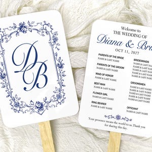 May include: Two rectangular wedding program fans with rounded corners and wooden handles. One side features a blue floral border and the monogram DB. The other side displays the text Welcome to THE WEDDING OF Diana & Brian OCT 11, 2027.