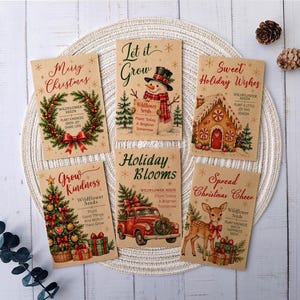 May include: Six rectangular seed packets with kraft paper backgrounds, each featuring festive illustrations including a wreath, snowman, gingerbread house, Christmas tree, red truck, and deer, with text like Merry Christmas and Let it Grow.