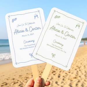 May include: Two rectangular wedding ceremony hand fans with wooden handles. One fan features blue text and graphics, the other green. Both display "Join Us To Celebrate", "Alicia & Carter", "March 15, 2027", "Ceremony", and "The Grand Hotel".