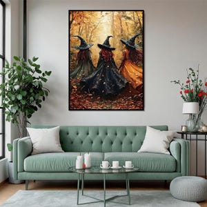 May include: A framed wall art print depicting three figures wearing pointed hats and long flowing cloaks in shades of black, green, and orange, standing in a forest filled with autumn leaves and golden light, presented in a black frame.