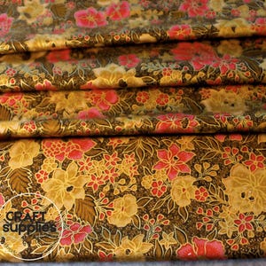 May include: Folded fabric with a floral design. The fabric has a dark brown base with gold, pink, and yellow flowers and leaves. The words "Craft Supplies" are visible in a white circle.