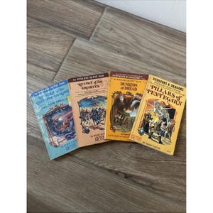 May include: Four vintage Dungeons & Dragons Endless Quest paperback books by Rose Estes. Titles include Revenge of the Rainbow Dragons, Revolt of the Dwarves, Dungeon of Dread, and Pillars of Pentegarn, each featuring colorful cover illustrations.