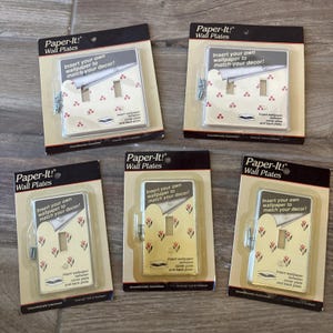 Puede incluir: Cinco placas de pared Paper-It! en su embalaje original. Cada placa está diseñada para permitir al usuario insertar su propio papel tapiz para que coincida con su decoración. El texto "Insert your own wallpaper to match your decor!" está incluido.