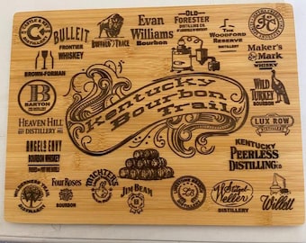 Op de afbeelding: Een rechthoekige bamboe snijplank met een lasergeëtst ontwerp met de woorden "Kentucky Bourbon Trail" en diverse distilleerderijlogo's. De plank bevat logo's voor Bulleit, Buffalo Trace, Maker's Mark en Jim Beam.