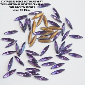 May include: A collection of vintage amethyst navette crystals. The crystals are foil-backed and measure 4mm by 15mm. Some crystals have a purple hue, while others have a golden color. The text in the image reads: VINTAGE 50 PIECE LOT RARE VERY THIN AMETHYST NAVETTE CRYSTAL FOIL BACKED STONES 4mm BY 15mm.