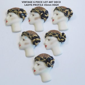 May include: Six vintage Art Deco lady's profile figurines. Each figurine is 45mm high and features a white face with red lips, delicate eye makeup, and a decorative headdress with gold and black accents. The text at the top reads "VINTAGE 6 PIECE LOT ART DECO LADYS PROFILE 45mm HIGH."