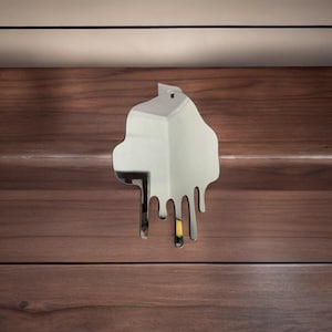 May include: A silver-coloured, abstract, dripping mirror in the shape of a cloud. The mirror is hanging on a wooden wall.