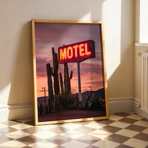 Pode incluir: Impress&atilde;o emoldurada com uma placa de motel vintage com a palavra "MOTEL" em n&eacute;on vermelho brilhante contra um c&eacute;u ao p&ocirc;r do sol. A cena inclui cactos e vegeta&ccedil;&atilde;o des&eacute;rtica, criando uma est&eacute;tica de paisagem des&eacute;rtica retr&ocirc;.