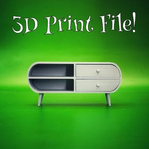 May include: A light gray, 3D-printed miniature cabinet with two drawers and two open shelves. The cabinet has rounded edges and sits on four small legs. The text "3D Print File!" is displayed above the cabinet against a green background.