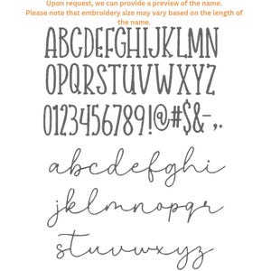 May include: Image displaying different font styles, including uppercase and lowercase alphabets, numbers, and symbols. The fonts are in grey. The text "Upon request, we can provide a preview of the name. Please note that embroidery size may vary based on the length of the name." is also visible.