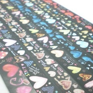 Puede incluir: Surtido de rollos de cinta washi negra y blanca con corazones coloridos y texto. El texto incluye "Love", "Start", "Live Well", "Smile" y "Happy".