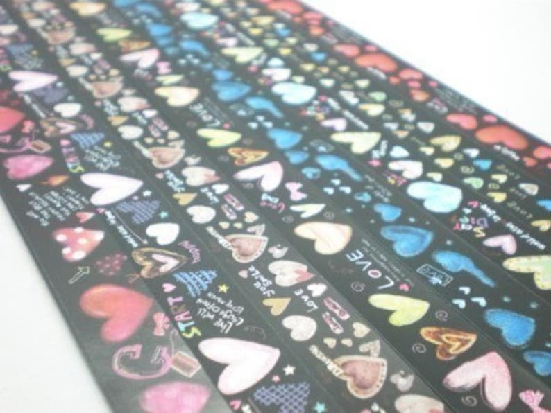 Puede incluir: Surtido de rollos de cinta washi negra y blanca con corazones coloridos y texto. El texto incluye "Love", "Start", "Live Well", "Smile" y "Happy".