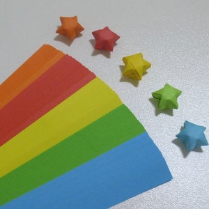 以下が含まれることがあります： 虹色の紙のストリップと、オレンジ、赤、黄色、緑、青、紫の6つの折り紙の星