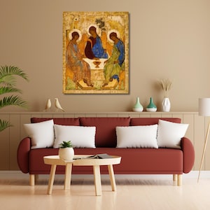 May include: An antique religious icon depicting three figures seated around a table. The figures are robed in blue, green, and orange hues, with halos. The artwork is displayed on a wall above a red sofa, enhancing the room's decor.