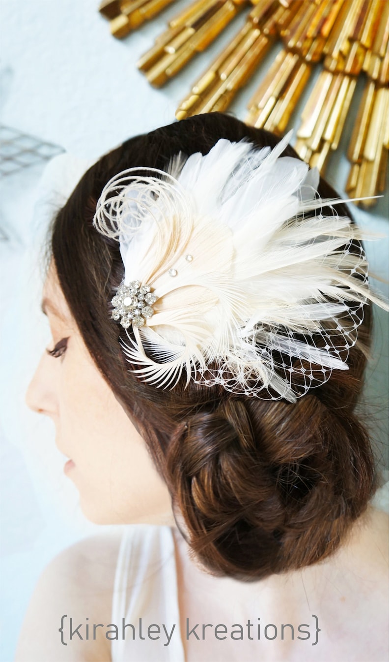 Puede incluir: Un peine de pelo de plumas blancas con un adorno de cristal. El peine se lleva en el pelo casta&ntilde;o de una mujer.