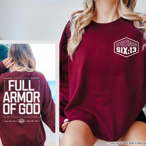 May include: Maroon sweatshirt with the text "FULL ARMOR OF GOD" on the back and "EPHESIANS SIX:13" on the front. The sweatshirt is a solid maroon color.