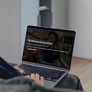 May include: A laptop displaying "The Waitress's Survival Guide" on its screen. The guide's subtitle is "How to Serve, Survive, and Not Let a Bad Tip Ruin Your Night." The laptop is open, and the user is typing on the keyboard.