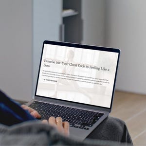 Puede incluir: Una persona usando una computadora portátil que muestra el texto "Exercise 101: Your Cheat Code to Feeling Like a Boss." La pantalla muestra una guía sobre el ejercicio. La computadora portátil está abierta.