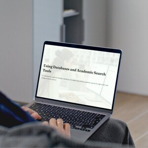 Puede incluir: Un portátil con el texto "Using Databases and Academic Search Tools" en la pantalla. La pantalla muestra información sobre la búsqueda, evaluación y organización de fuentes académicas creíbles para proyectos de investigación de secundaria y universidad. El portátil está abierto.