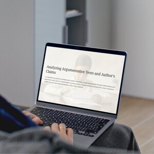 May include: A laptop displaying the text "Analyzing Argumentative Texts and Author's Claims". The screen shows text and an image. The keyboard is visible, and the person's hands are on the keyboard. The laptop is open.