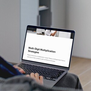 May include: A laptop displaying a webpage titled "Multi-Digit Multiplication Strategies." The text below states, "Ready to become a multiplication master? Keep scrolling to learn how to solve big number problems with confidence and ease!"