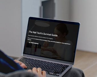 May include: A person using a laptop displaying "The Nail Tech's Survival Guide." The screen shows text about staying sane while managing nail supplies. The laptop is open, and the person's hands are visible on the keyboard.