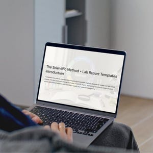 Może przedstawiać: Laptop z tekstem "The Scientific Method + Lab Report Templates" na ekranie. Laptop jest otwarty, wyświetlając dokument o metodzie naukowej. Klawiatura jest widoczna. Laptop znajduje się na kolanach osoby.