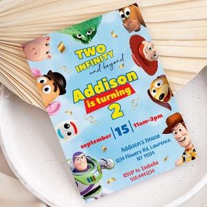 May include: A light blue invitation card featuring characters from the animated film "Toy Story." The card reads "Two Infinity and Beyond" and "Addison is turning 2." Additional text includes the date, time, location, and RSVP information.