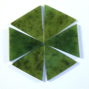 May include: Six triangular jade stones arranged in a hexagonal pattern. The stones are a deep green color with darker green and black inclusions, and are set against a white background. The stones are likely for jewelry making or other crafts.