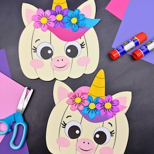 Puede incluir: Dos manualidades de papel con forma de calabaza unicornio con cuerpos color crema, cuernos amarillos y coronas de flores en rosa, morado y azul. Cada una tiene grandes ojos negros, mejillas rosadas y una boca sonriente. Texto simple everyday mom.