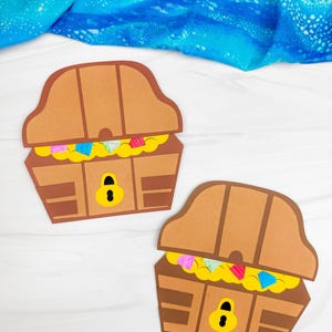 Op de afbeelding: Twee papieren schatkisten in bruin met donkerbruine accenten, voorzien van een geel slot en gevuld met gele gouden munten en kleurrijke edelstenen in blauw, roze en lichtgroen, gepresenteerd als platte papieren uitsparingen.