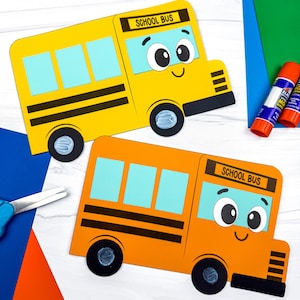 Op de afbeelding: Twee papieren schoolbus-uitsparingen, één geel en één oranje, elk met lichtblauwe ramen, zwarte wielen en een bordje met de tekst SCHOOL BUS. De bussen hebben cartoongezichten met grote ogen en een glimlach, gemaakt van karton.