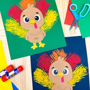 May include: Two colorful turkey crafts made of brown paper with red, yellow, and orange feathers. The turkeys have large eyes, yellow beaks, and red wattles. Blue scissors, glue sticks, and colored paper are also visible.