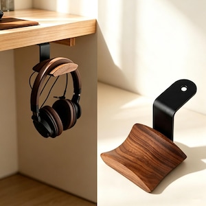 May include: A headphone stand featuring a curved dark wood grain cradle attached to a matte black metal bracket. The bracket is designed to hook onto the edge of a desk, providing a secure mount for over-ear headphones with brown ear cups.