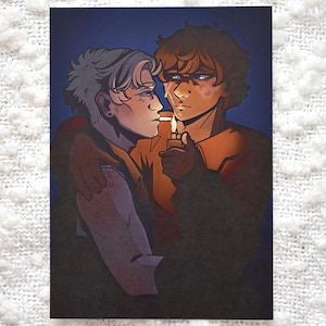 May include: Illustration of two figures in a close embrace, one lighting a cigarette for the other. The artwork features a warm color palette with orange and brown tones, set against a dark blue background. The style is reminiscent of a romantic or intimate scene.