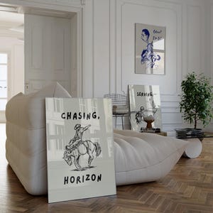 Pode incluir: Uma sala de estar moderna e luminosa com um grande sofá branco almofadado. As obras de arte incluem uma impressão com um cowboy a cavalo e as palavras "Chasing, Horizon". Outras impressões e uma pequena planta também são visíveis.