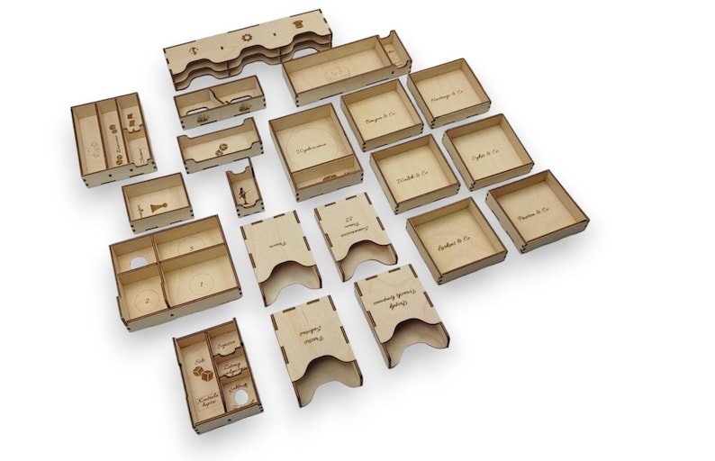 May include: A collection of laser-cut wooden game organizer components. Various shapes and sizes include trays, boxes, and dividers. Some pieces have engraved text, such as "Phantasms & Co." and "Scythe & Co.", suggesting a board game theme.