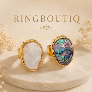 May include: Two gold-toned rings with large, irregularly shaped stones. One ring features a white, iridescent stone, while the other has a colorful, abalone-like stone. The rings are displayed on a neutral surface, with the text "RINGBOUTIQ" above.