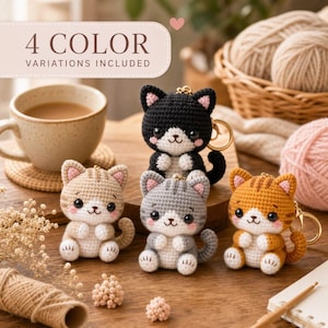Può includere: Quattro portachiavi a forma di gatto all'uncinetto in nero, marrone chiaro, grigio e arancione, ciascuno con muso bianco, guance rosa e un anello in metallo dorato. Il testo 4 COLOR VARIATIONS INCLUDED è in un riquadro rosa chiaro in alto.