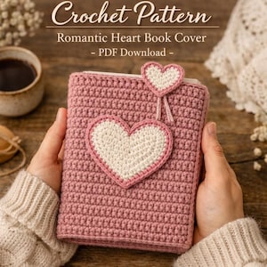 May include: A pink crochet book cover with a white heart applique and a smaller heart attached with string. The text "Crochet Pattern" and "Romantic Heart Book Cover - PDF Download -" are at the top of the image. The book cover is held by a person.