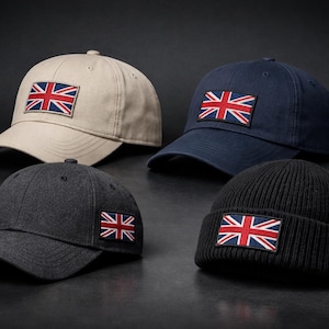 Könnte beinhalten: Vier Hüte mit dem Union Jack. Zwei Baseballkappen in Beige und Marineblau, eine dunkelgraue Baseballkappe und eine schwarze Mütze. Jeder Hut hat einen rechteckigen Aufnäher mit der britischen Flagge.
